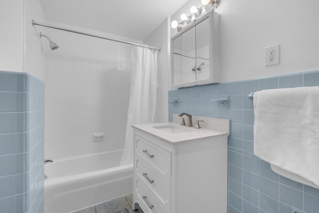 full bath with tile walls, shower / tub combo with curtain, and vanity