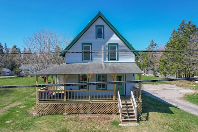 rear view of property with a porch, a lawn, and roof with shingles