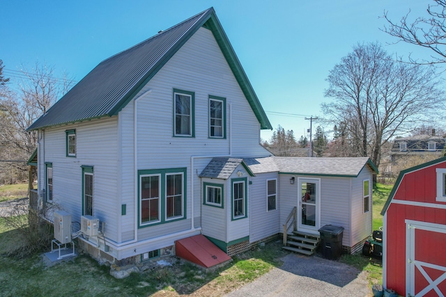 back of house with ac unit, an outbuilding, a shed, and entry steps