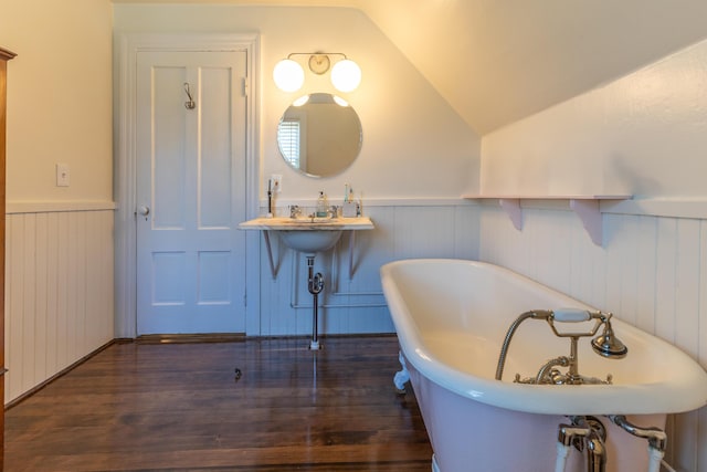 full bathroom with a freestanding tub, wainscoting, wood finished floors, and lofted ceiling