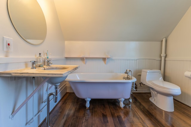 bathroom featuring wood-type flooring, wainscoting, a freestanding bath, and toilet