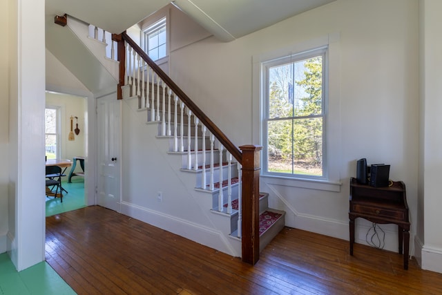 staircase featuring a wealth of natural light and hardwood / wood-style flooring