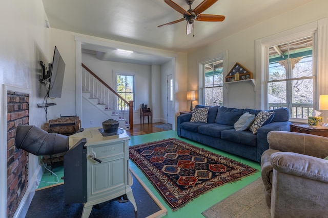 living room featuring plenty of natural light, ceiling fan, and stairway