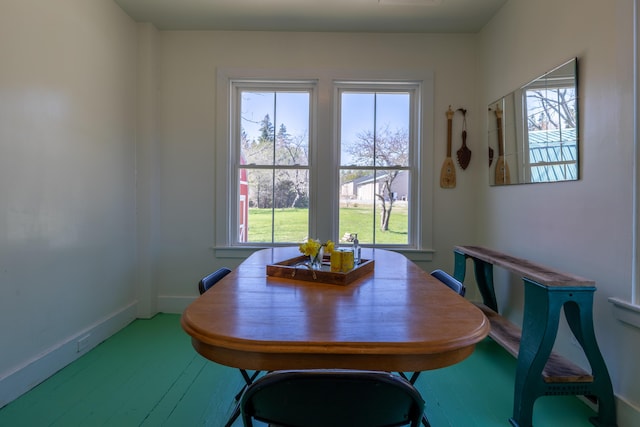 dining space with baseboards and wood finished floors