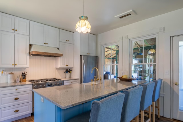 kitchen featuring visible vents, light stone countertops, white cabinets, under cabinet range hood, and stainless steel appliances