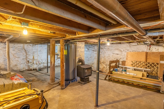 unfinished basement featuring a wood stove and electric water heater