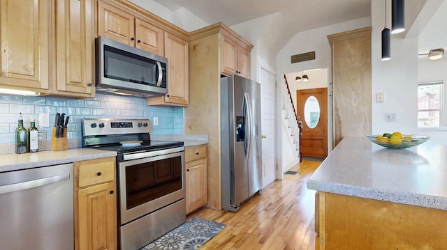 25 Nevens St Unit 1, Portland, ME 04103 - kitchen with appliances with stainless steel finishes, light brown cabinets, light wood-style flooring, backsplash, and lofted ceiling