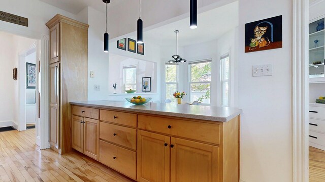 25 Nevens St Unit 1, Portland, ME 04103 - kitchen featuring light wood-style flooring, a peninsula, a chandelier, and light countertops