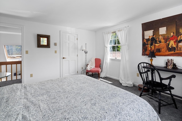 bedroom with baseboards and dark carpet