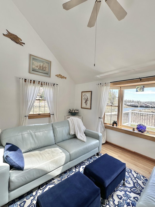 living area with light wood-style floors, ceiling fan, vaulted ceiling, and a healthy amount of sunlight