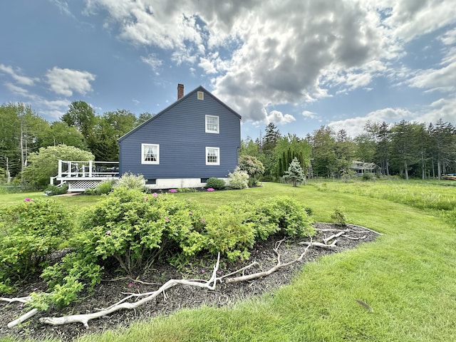 156 Scraggle Point Rd, Saint George, ME 04859 - view of side of property with a chimney, a wooden deck, and a lawn