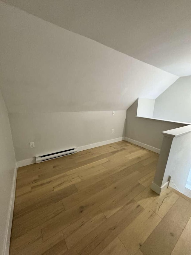 bonus room featuring baseboards, a baseboard heating unit, wood finished floors, and lofted ceiling