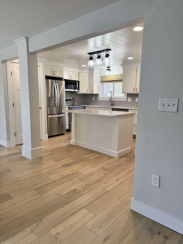 kitchen with light countertops, stainless steel appliances, baseboards, and decorative backsplash