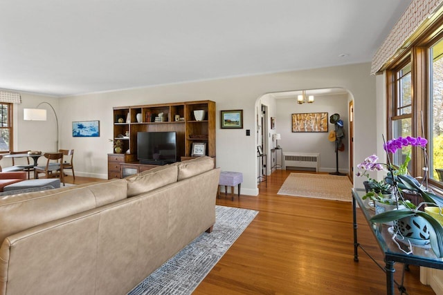 69 Brookside Rd, Portland, ME 04103 - living room with radiator, arched walkways, wood finished floors, baseboards, and crown molding