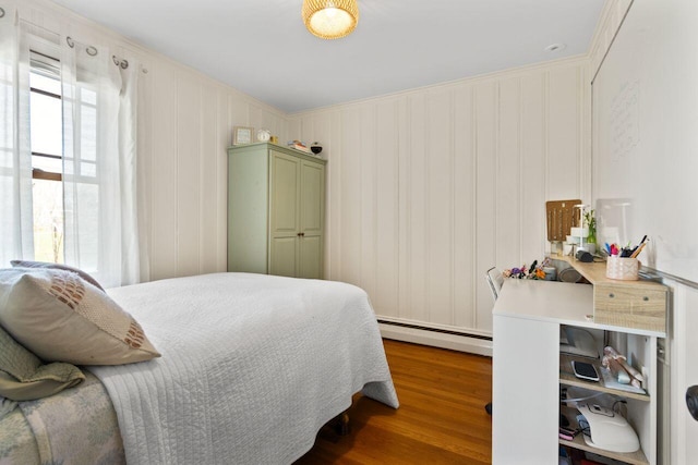 69 Brookside Rd, Portland, ME 04103 - bedroom with baseboard heating, wood finished floors, and a decorative wall