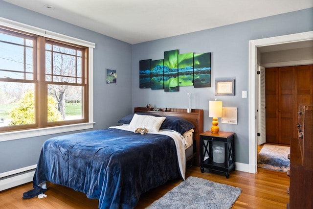 69 Brookside Rd, Portland, ME 04103 - bedroom featuring baseboard heating, multiple windows, wood finished floors, and baseboards