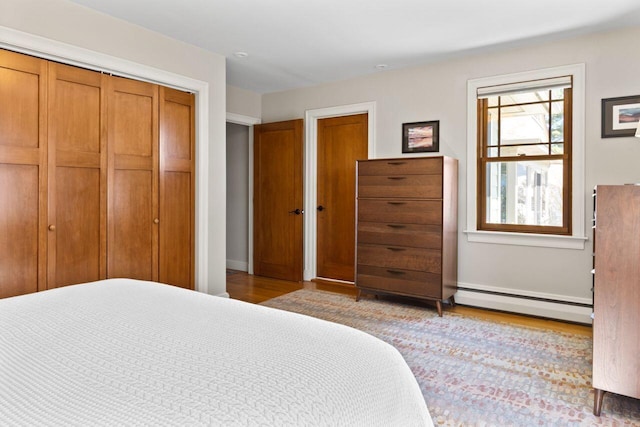 69 Brookside Rd, Portland, ME 04103 - bedroom with baseboard heating, wood finished floors, a closet, and baseboards
