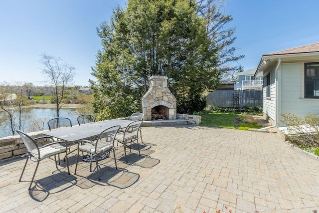 69 Brookside Rd, Portland, ME 04103 - view of patio / terrace with an outdoor stone fireplace, outdoor dining space, and a water view