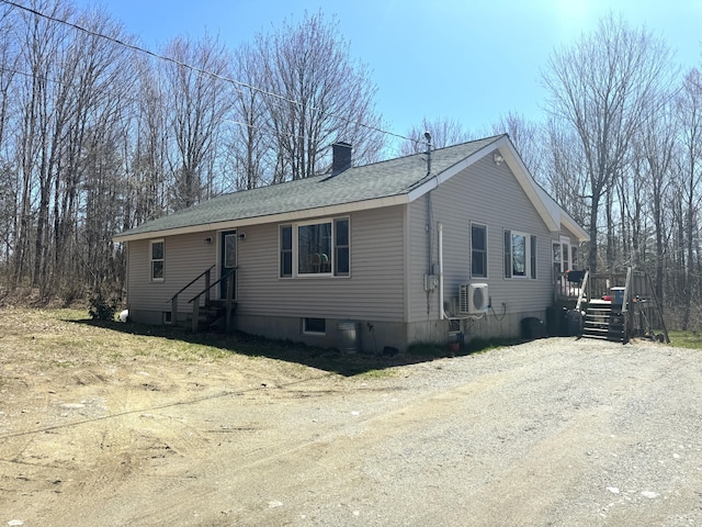 76 Norton Hill Rd, Dover-Foxcroft, ME 04426 - manufactured / mobile home featuring roof with shingles, ac unit, a wooden deck, entry steps, and a chimney