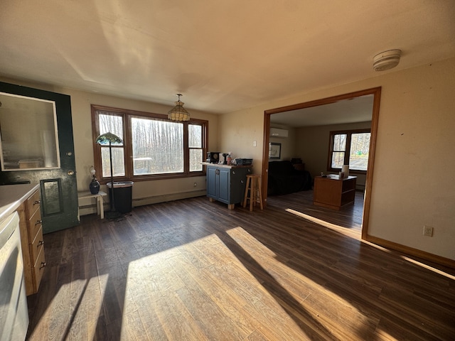 76 Norton Hill Rd, Dover-Foxcroft, ME 04426 - unfurnished living room with baseboards, a wall unit AC, and dark wood-style floors