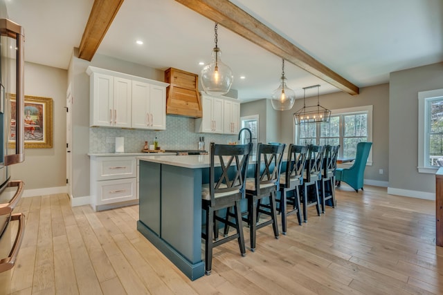 27 Oak Ridge Ter, Arundel, ME 04046 - kitchen featuring beam ceiling, baseboards, a center island with sink, light wood finished floors, and recessed lighting