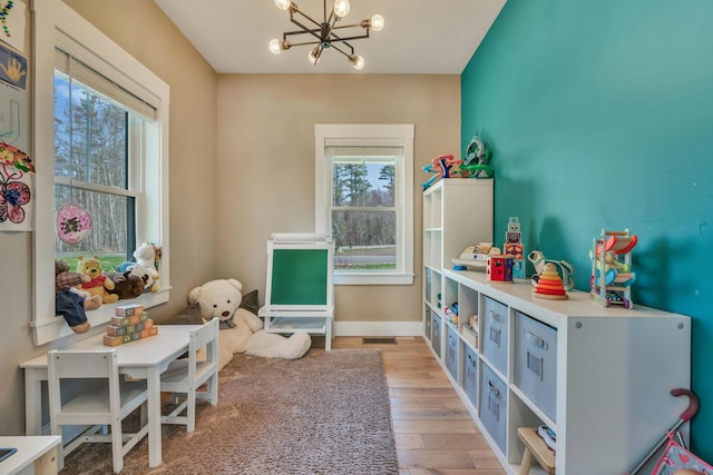 27 Oak Ridge Ter, Arundel, ME 04046 - playroom featuring a chandelier, plenty of natural light, wood finished floors, and baseboards