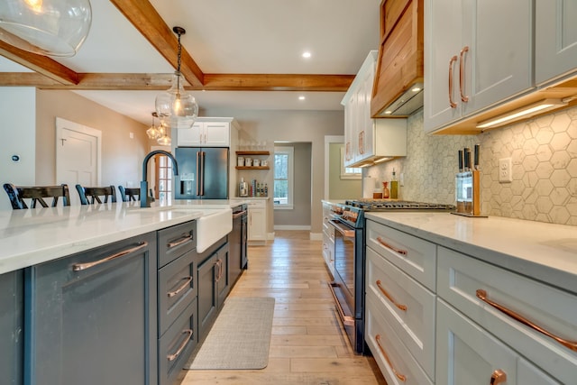 27 Oak Ridge Ter, Arundel, ME 04046 - kitchen with stainless steel appliances, beam ceiling, white cabinets, decorative backsplash, and light wood-style floors