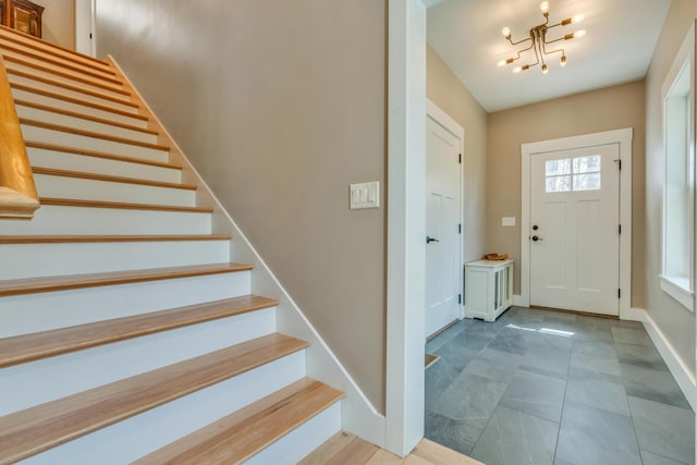 27 Oak Ridge Ter, Arundel, ME 04046 - entrance foyer featuring stairway, healthy amount of natural light, a chandelier, and baseboards