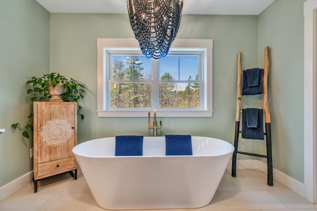 27 Oak Ridge Ter, Arundel, ME 04046 - bathroom with a chandelier, baseboards, a soaking tub, and tile patterned floors