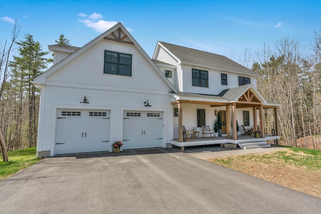 27 Oak Ridge Ter, Arundel, ME 04046 - modern inspired farmhouse featuring a porch, asphalt driveway, a garage, and roof with shingles