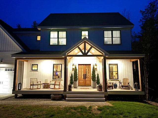 27 Oak Ridge Ter, Arundel, ME 04046 - back of house at twilight with french doors, a porch, and board and batten siding