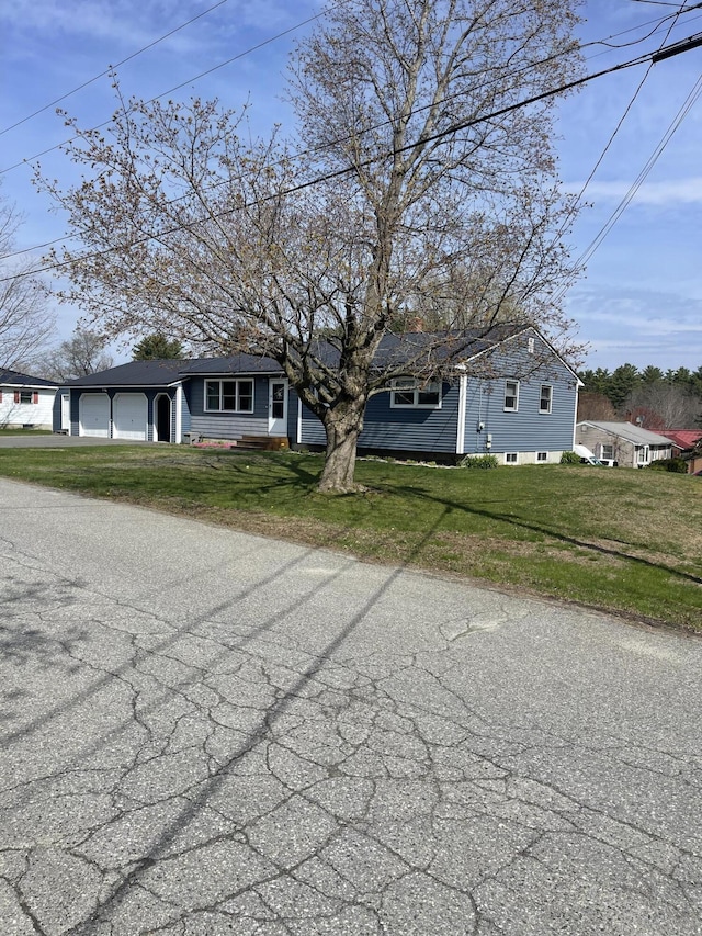 view of front of home featuring an attached garage and a front lawn