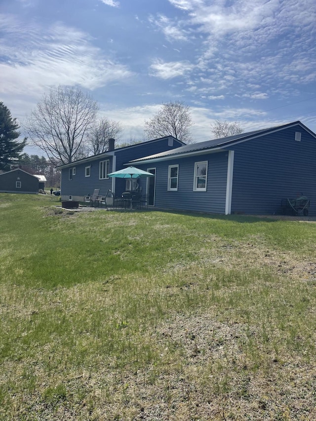 rear view of property with a yard and a chimney