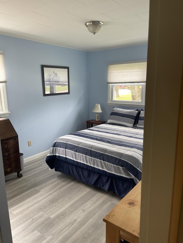 bedroom with baseboards and wood finished floors
