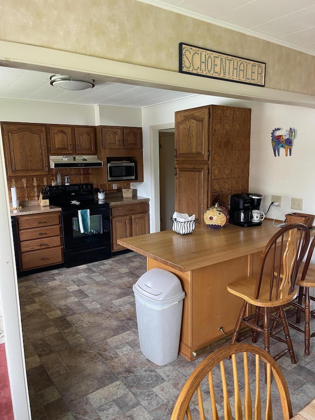 kitchen with under cabinet range hood, stainless steel microwave, a kitchen bar, a peninsula, and electric range