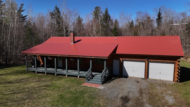exterior space with a garage, a chimney, a porch, and a front lawn