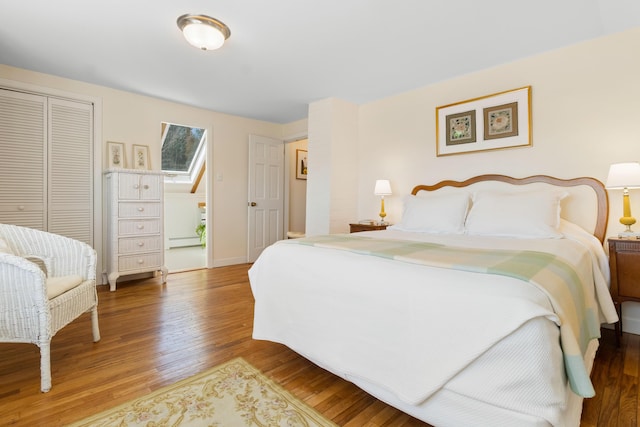 bedroom with baseboards, a closet, and wood finished floors