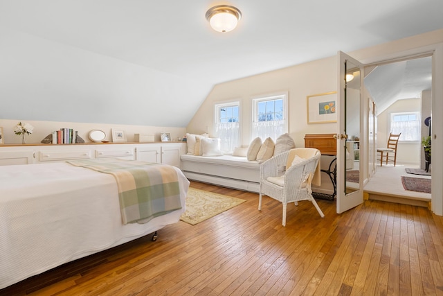 bedroom featuring light wood finished floors and lofted ceiling