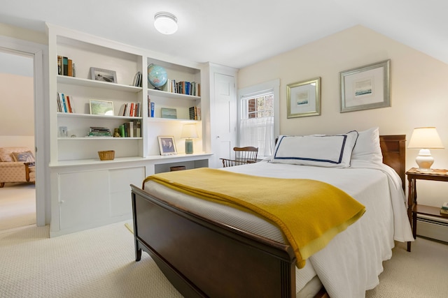bedroom with a baseboard heating unit and light colored carpet