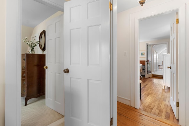 hall with baseboards and light wood-style flooring