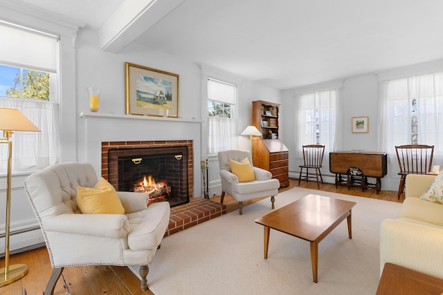 living area featuring a baseboard heating unit, a brick fireplace, and wood finished floors