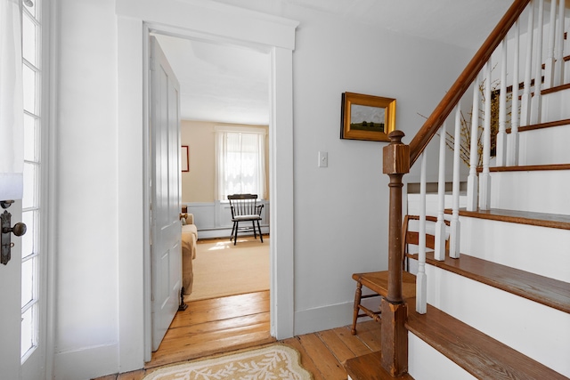 stairs with a baseboard radiator and hardwood / wood-style floors
