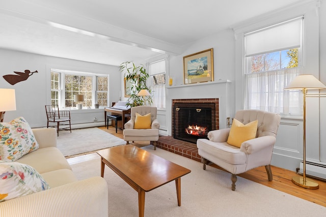 living room featuring a brick fireplace, wood finished floors, and baseboard heating
