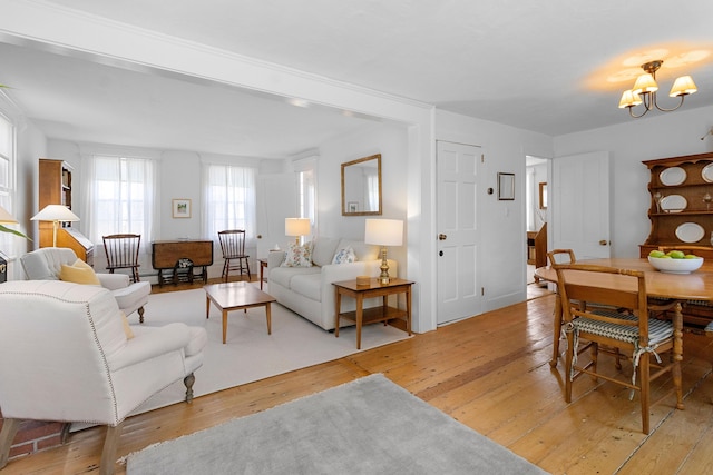 living area featuring light wood-type flooring and a notable chandelier