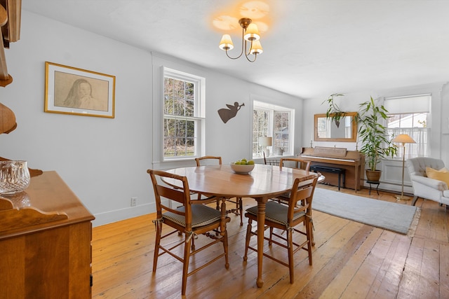 dining room with an inviting chandelier, light wood-type flooring, and a wealth of natural light