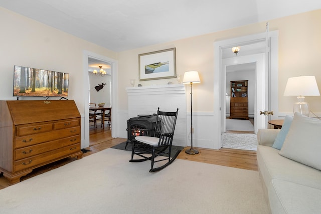 living area with wood finished floors and a wainscoted wall