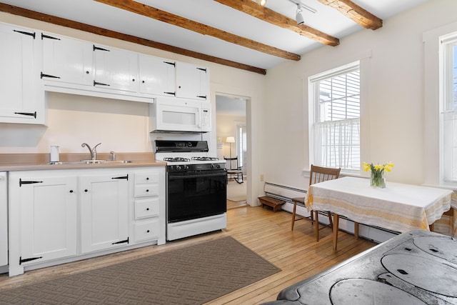 kitchen with range with gas cooktop, light wood-type flooring, beam ceiling, a sink, and white microwave