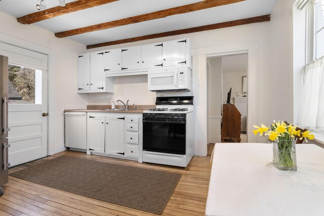 kitchen featuring light wood-type flooring, white cabinets, beamed ceiling, and white appliances