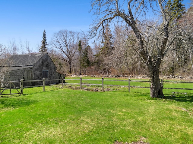 view of yard featuring a barn, fence, and an outbuilding