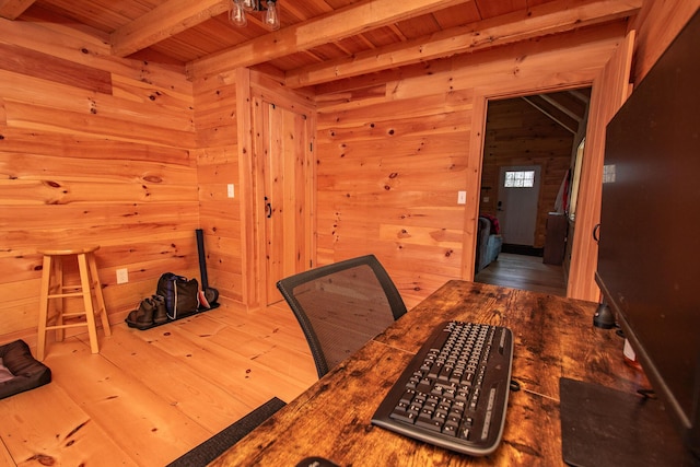 dining room featuring wood walls, hardwood / wood-style floors, wooden ceiling, and beamed ceiling